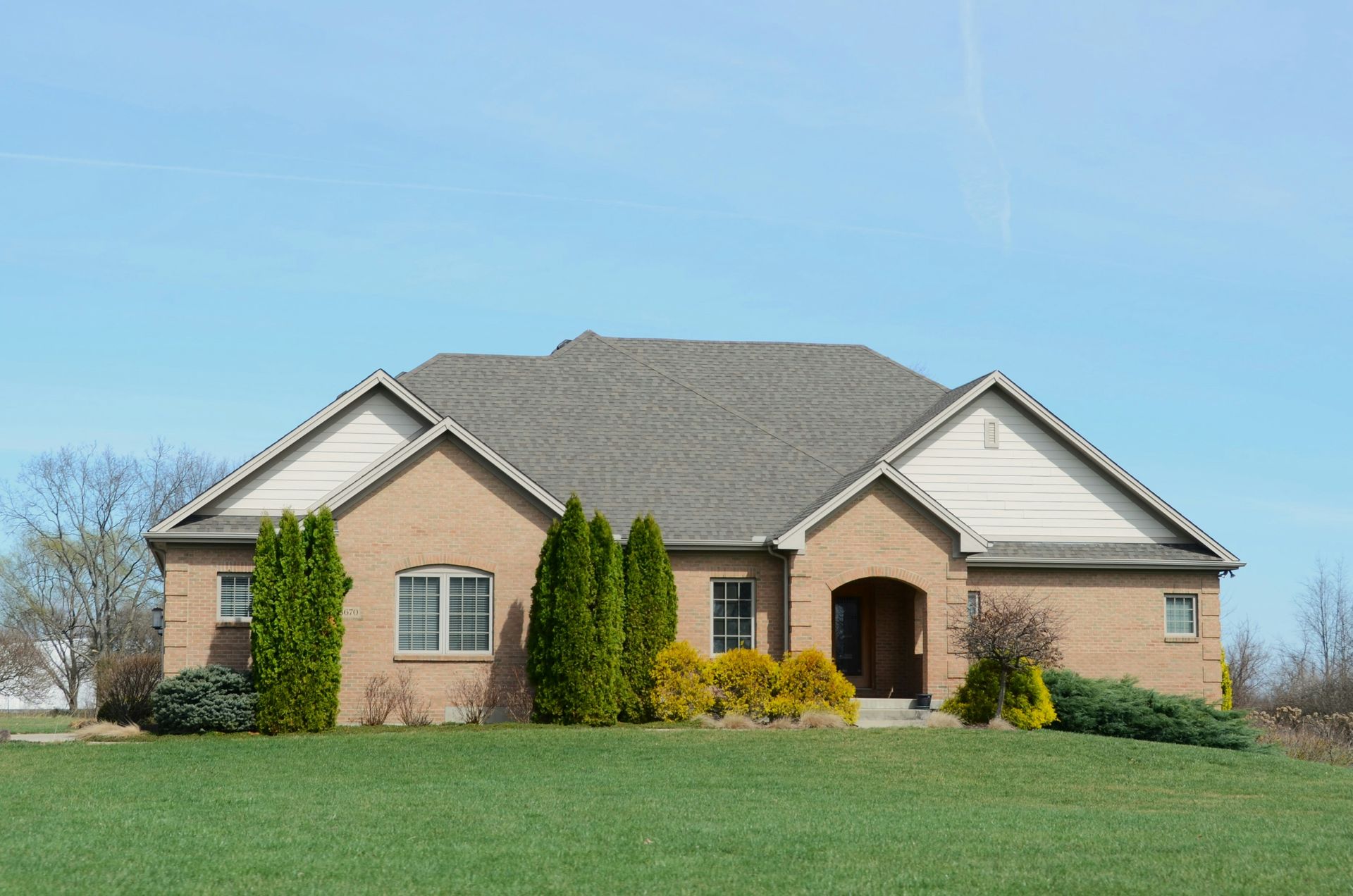 A suburban brick house with a well-kept lawn.